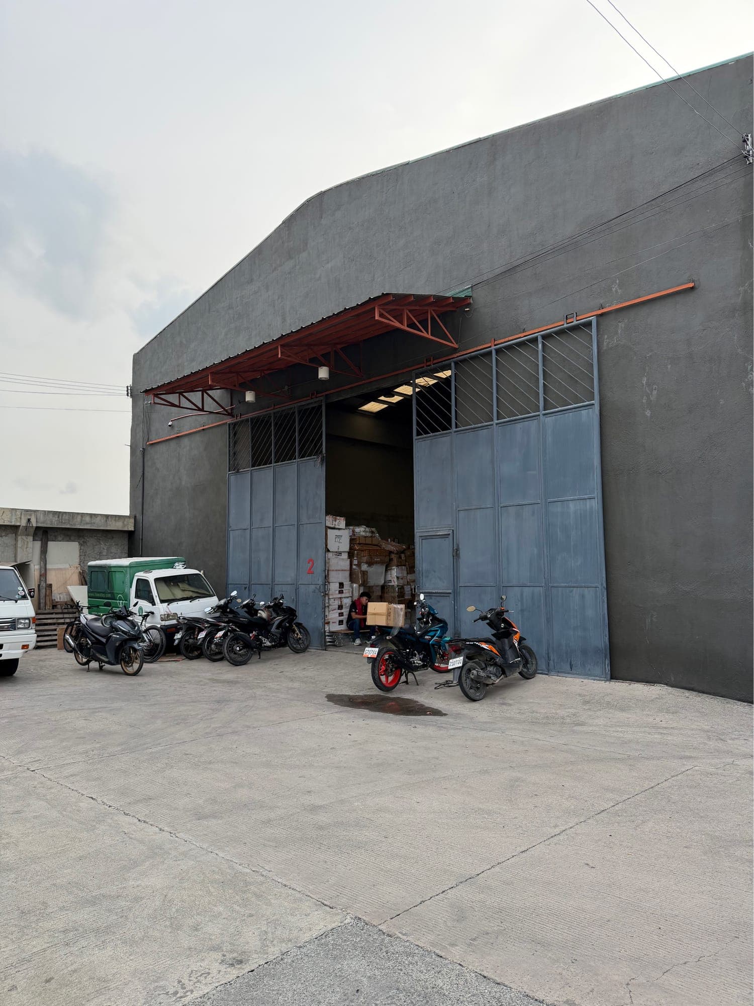 Warehouse front entrance with covered canopy and wide steel sliding doors